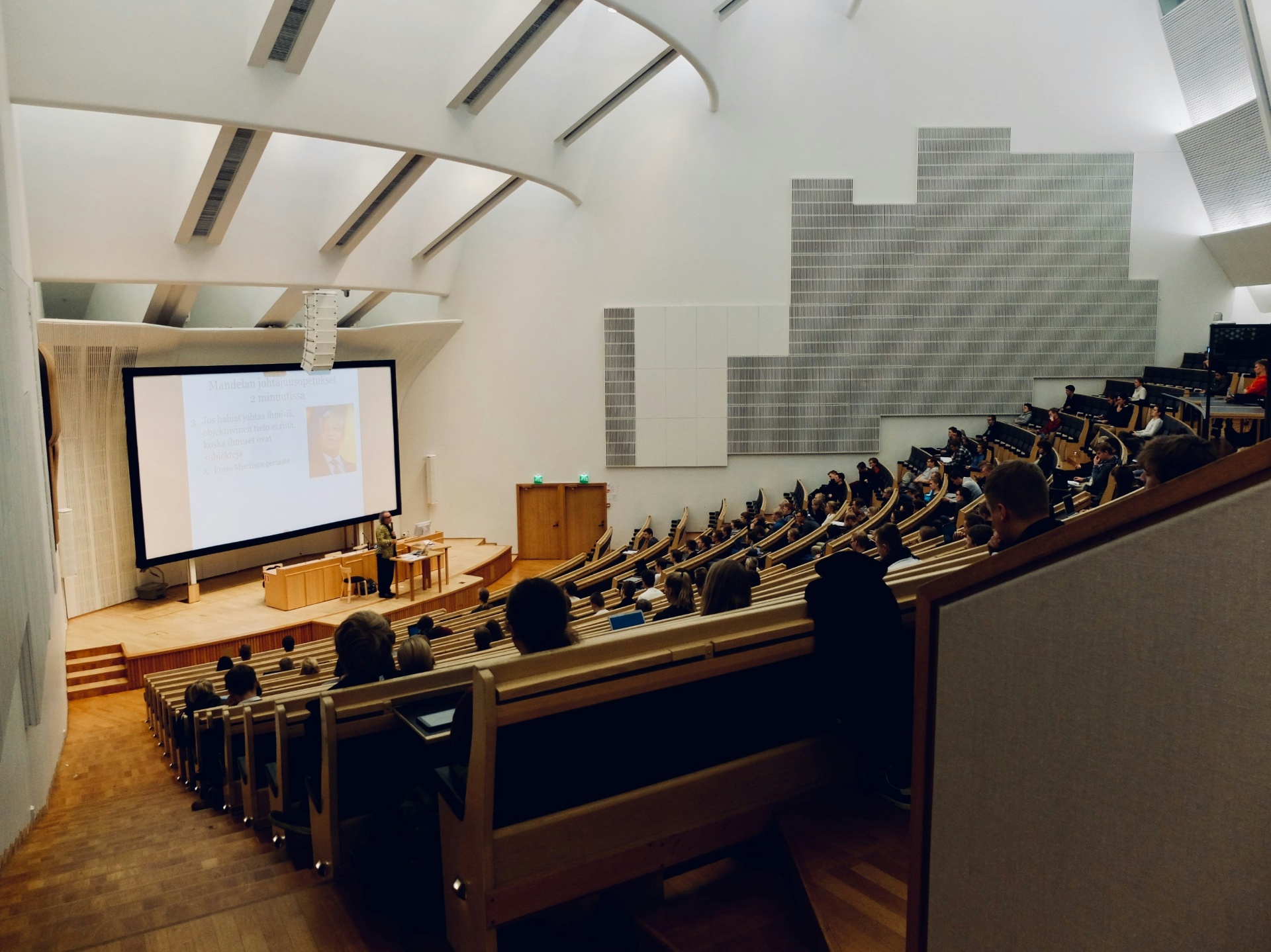 Students attending a lecture in a large university auditorium